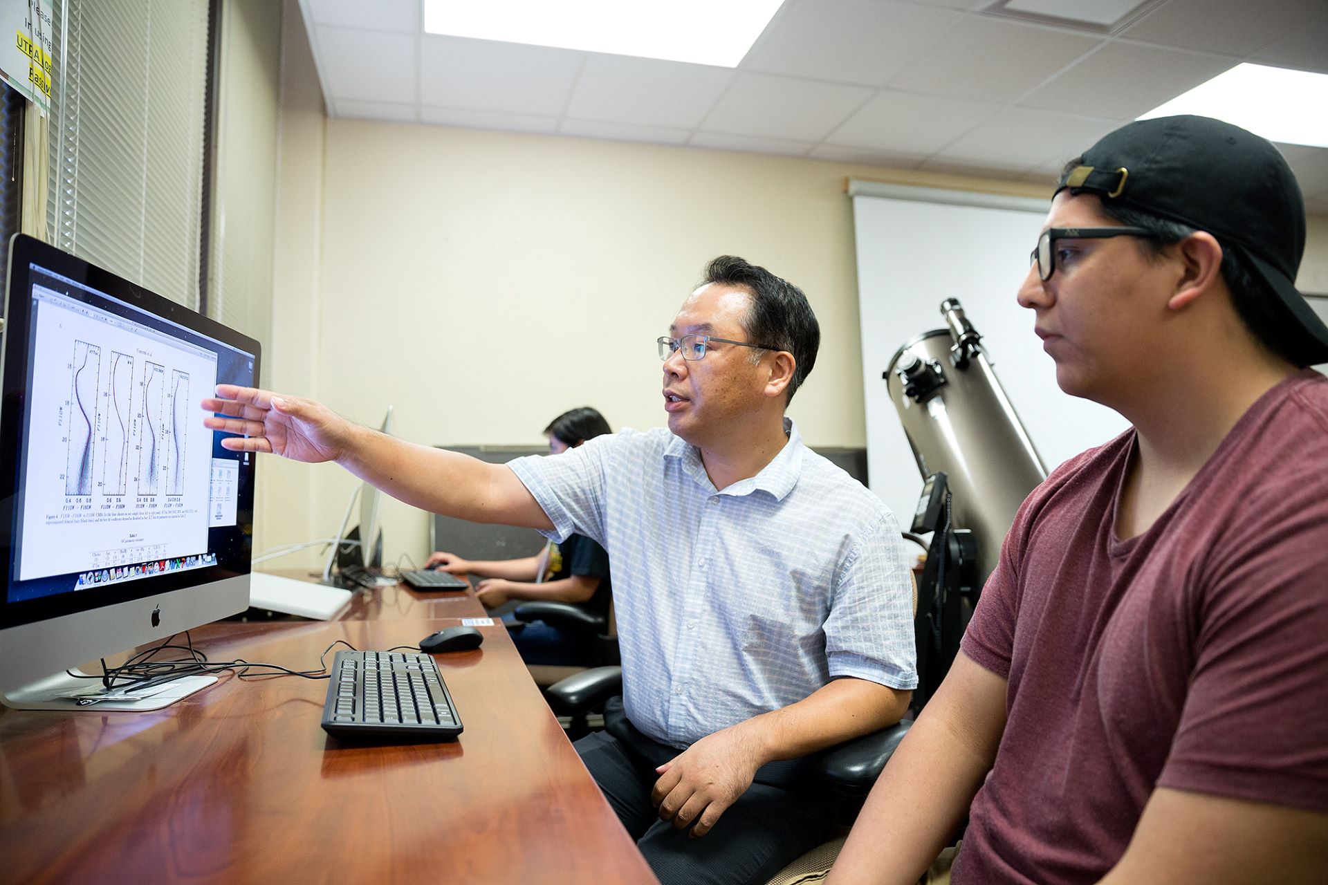 Professor showing computer screen to student Professor showing computer screen to student