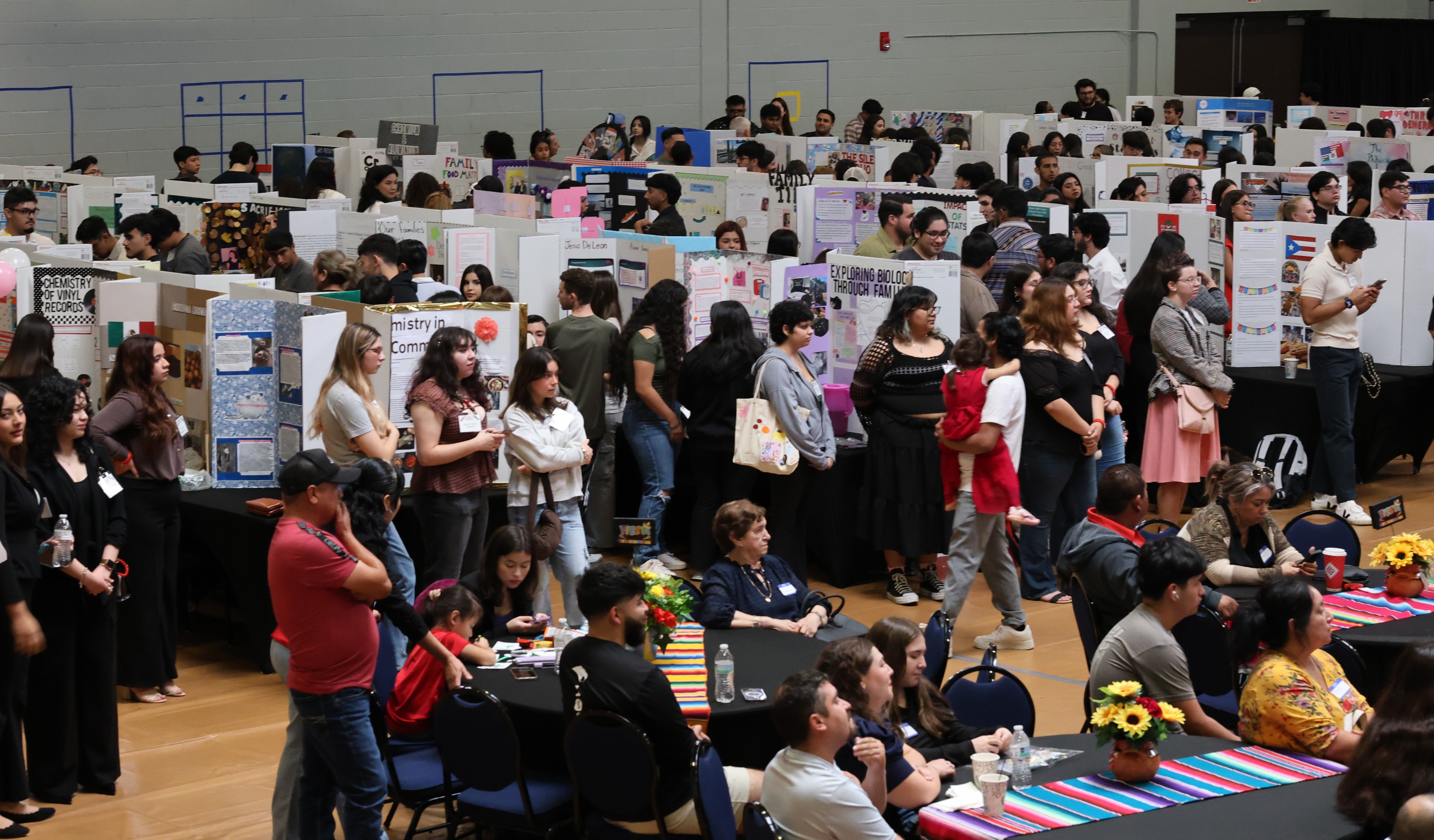Student participants wait for their turn to present their posters to attendees at the FIESTA Symposium.