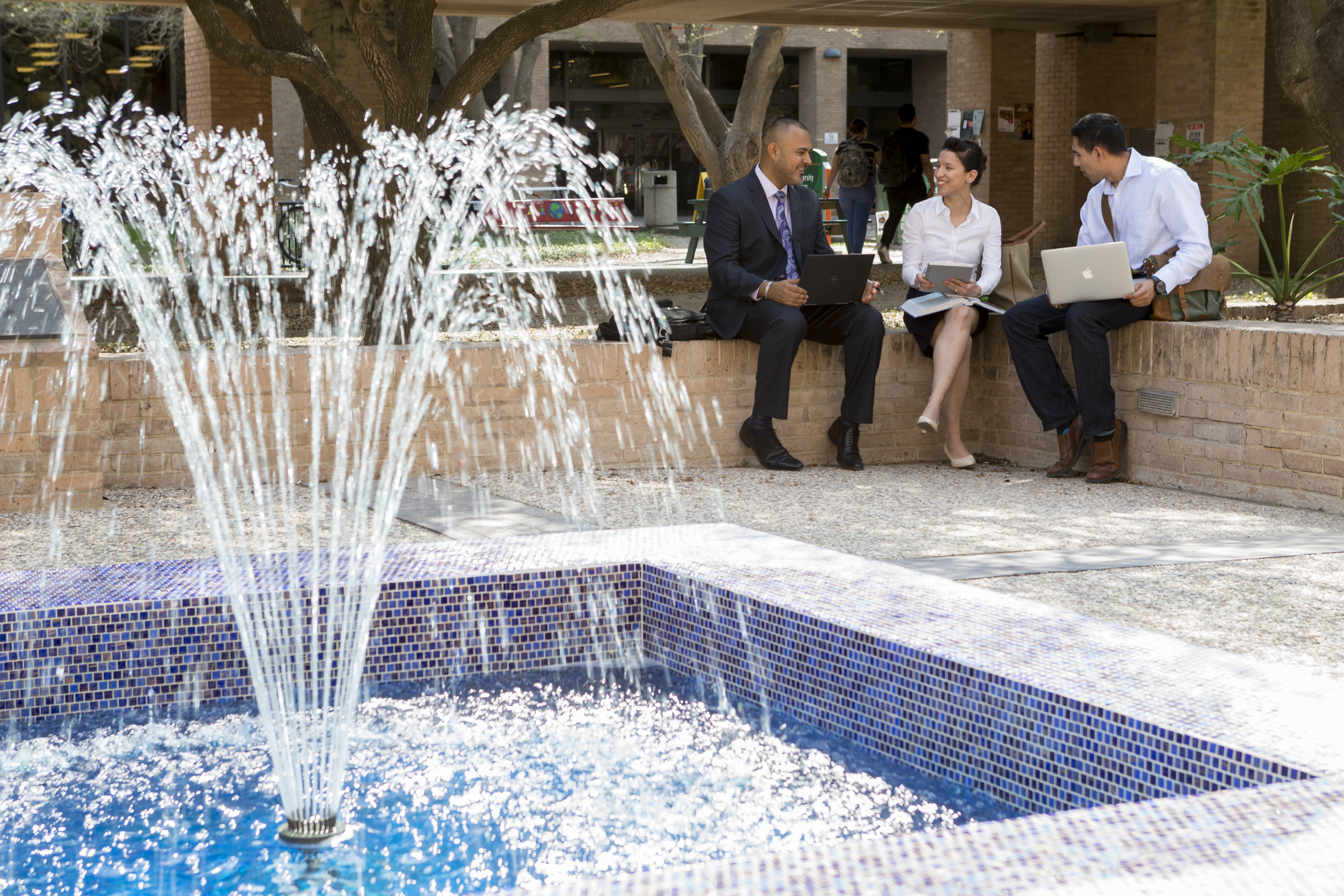 Business students talking near a fountain. Business students talking near a fountain.
